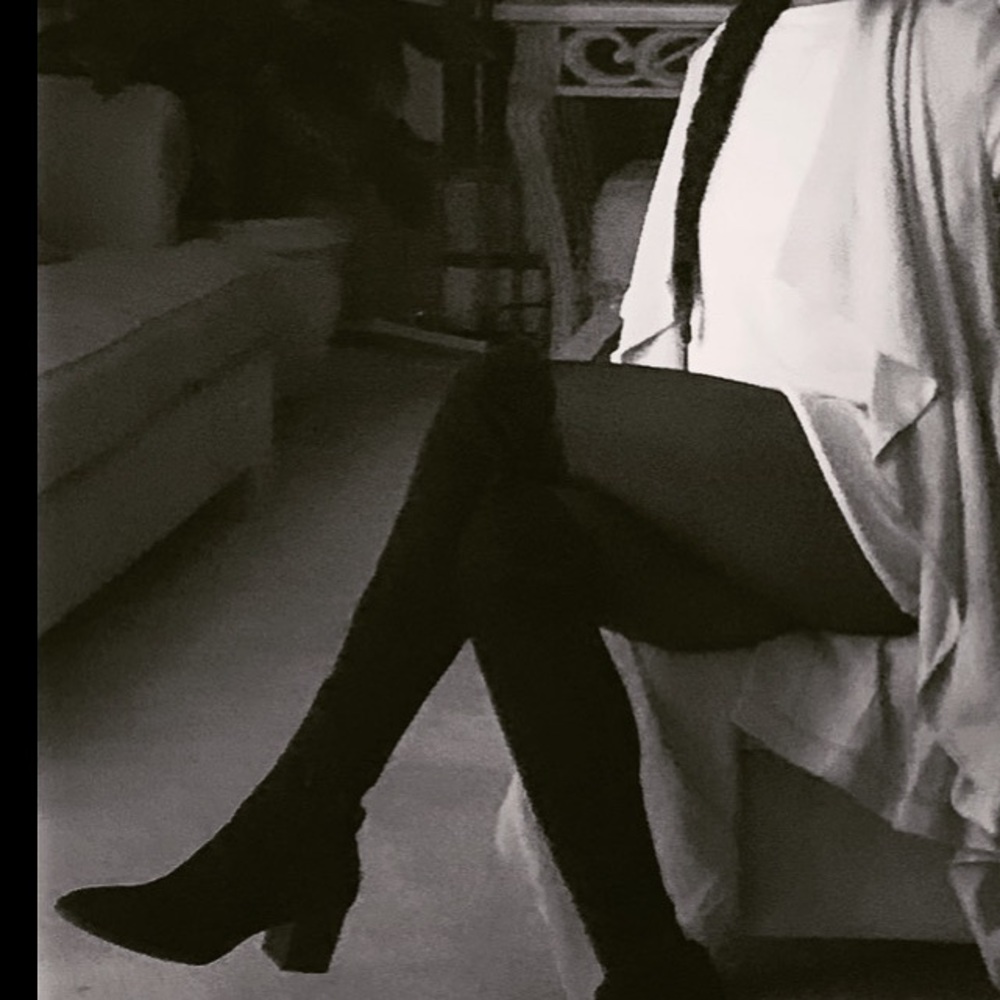 Knee high black boots go to the thigh.